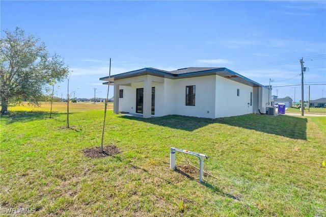 back of house with a yard and central AC unit