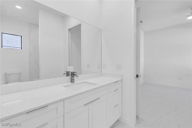 bathroom with vanity, ceiling fan, and toilet