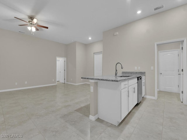 kitchen with light stone countertops, sink, ceiling fan, stainless steel dishwasher, and white cabinets