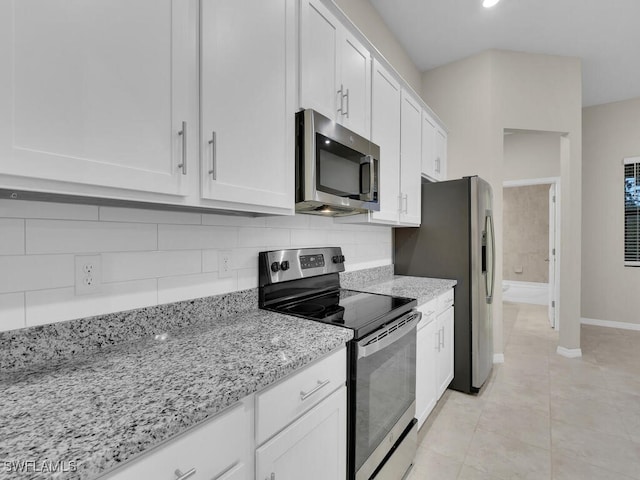 kitchen with light stone counters, white cabinets, and stainless steel appliances