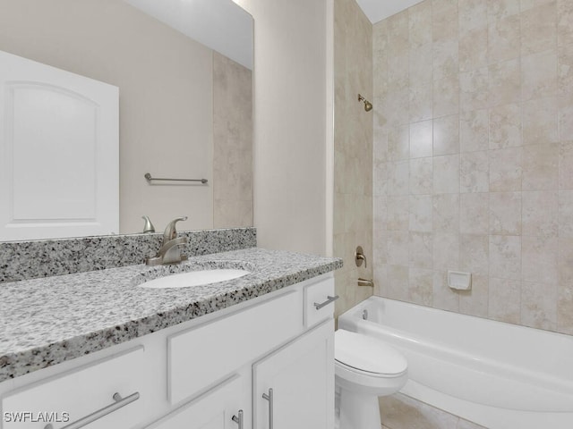 full bathroom with tile patterned flooring, vanity, tiled shower / bath combo, and toilet