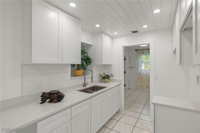 kitchen with sink, white cabinets, and light tile patterned floors