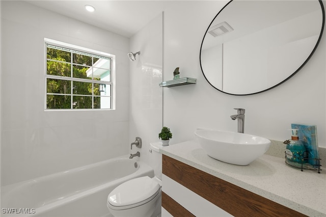 full bathroom featuring vanity, tiled shower / bath, and toilet