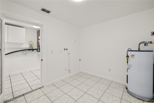 laundry room featuring water heater and light tile patterned floors