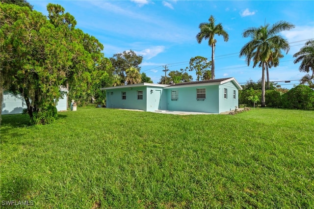 21 E Mariana Ave, North Fort Myers, FL 33917 - back of house with a yard and stucco siding