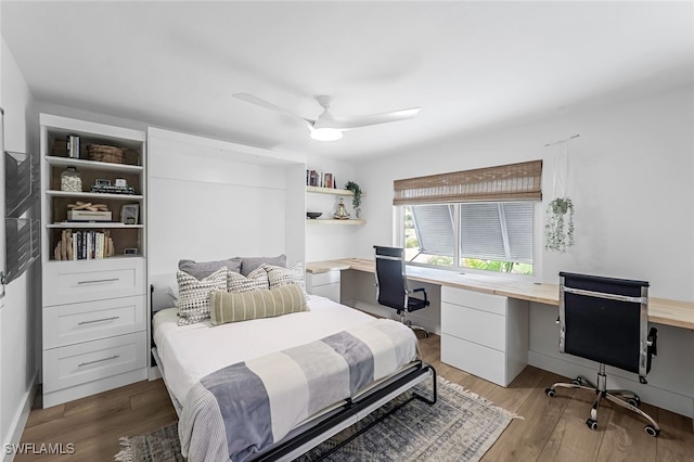 bedroom featuring wood-type flooring, built in desk, and ceiling fan