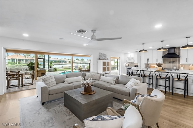 living room featuring ceiling fan and light hardwood / wood-style floors