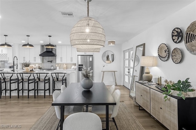 dining space with sink and light hardwood / wood-style flooring