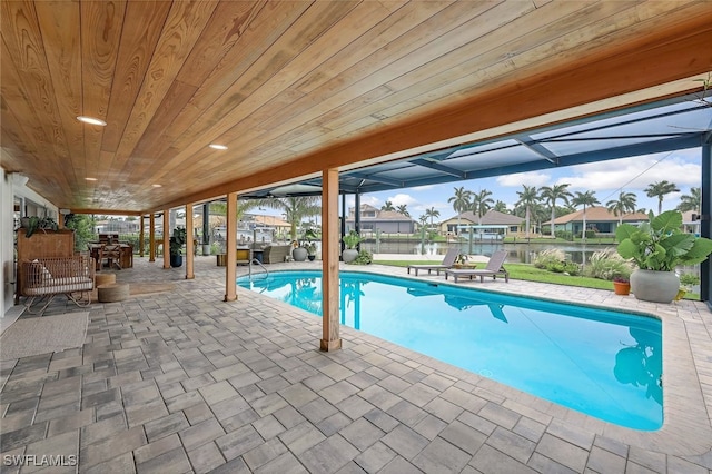 view of swimming pool with glass enclosure and a patio