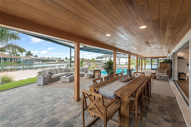 sunroom / solarium with a healthy amount of sunlight, a water view, and wood ceiling