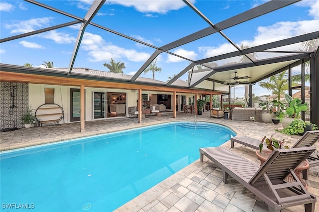 view of pool featuring a patio, an outdoor hangout area, glass enclosure, and ceiling fan