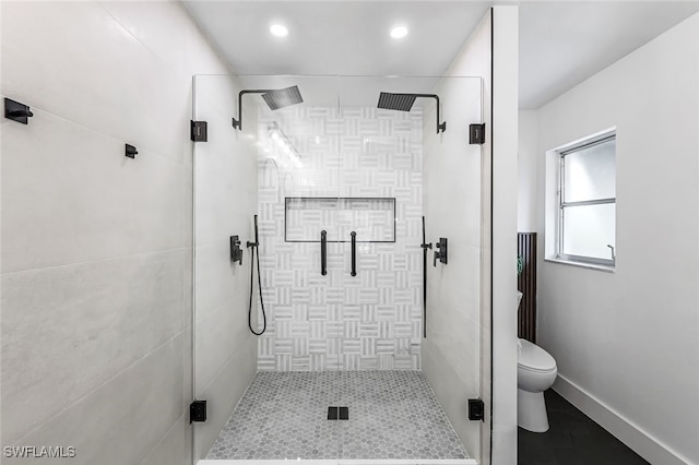 bathroom with toilet and a shower with door