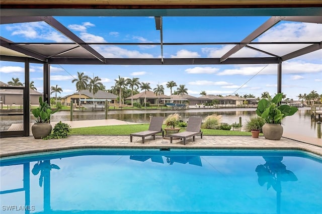 view of pool with a patio, a water view, and a lanai