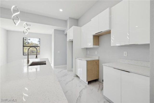 kitchen featuring white cabinetry and sink