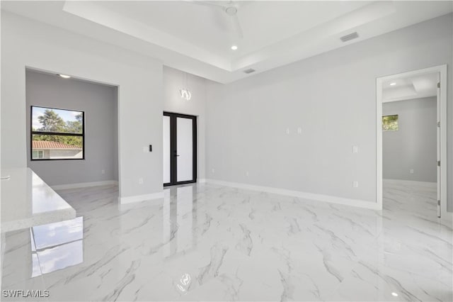 unfurnished room featuring a notable chandelier and a raised ceiling