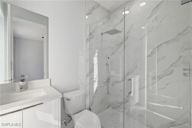 bathroom featuring vanity, toilet, and a shower with shower door