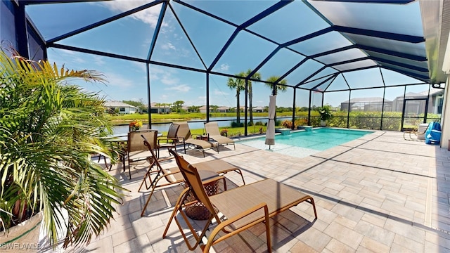 view of pool with a water view, glass enclosure, and a patio area