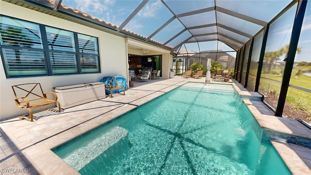 view of pool featuring pool water feature, a patio area, and a lanai