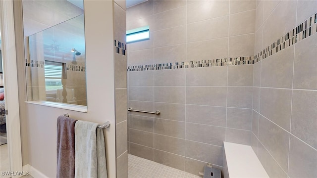 bathroom with tiled shower and a wealth of natural light