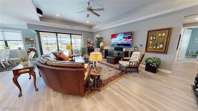 living room with light wood-type flooring, ceiling fan, and ornamental molding