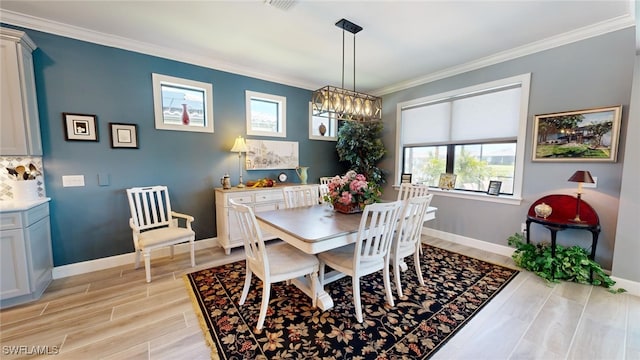 dining space featuring a chandelier, light hardwood / wood-style flooring, and ornamental molding