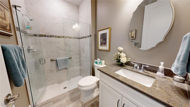 bathroom featuring vanity, an enclosed shower, and toilet