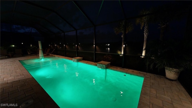 pool at twilight with a lanai and a patio