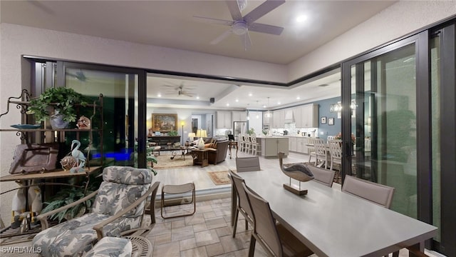 dining area featuring ceiling fan and a tray ceiling