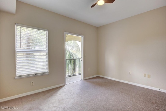 carpeted spare room with a wealth of natural light and ceiling fan