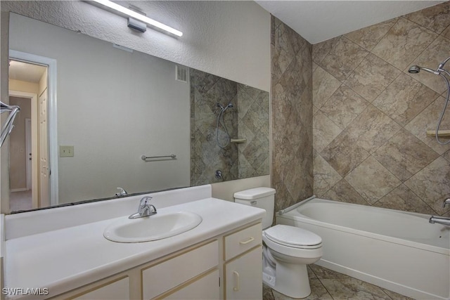 full bathroom featuring tiled shower / bath, vanity, tile patterned floors, and toilet