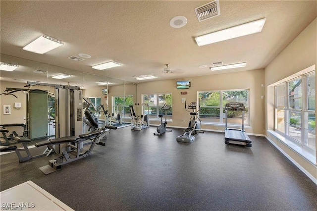 gym featuring plenty of natural light and a textured ceiling