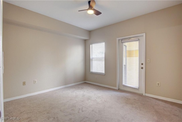 spare room featuring light colored carpet and ceiling fan