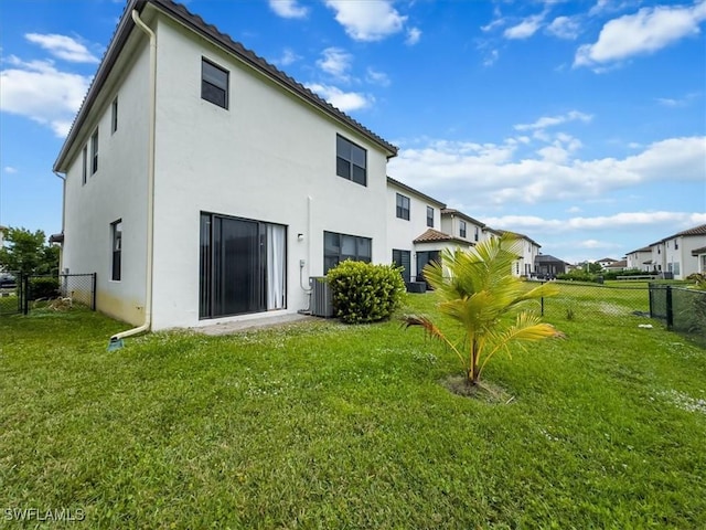 back of property with a lawn and central AC unit