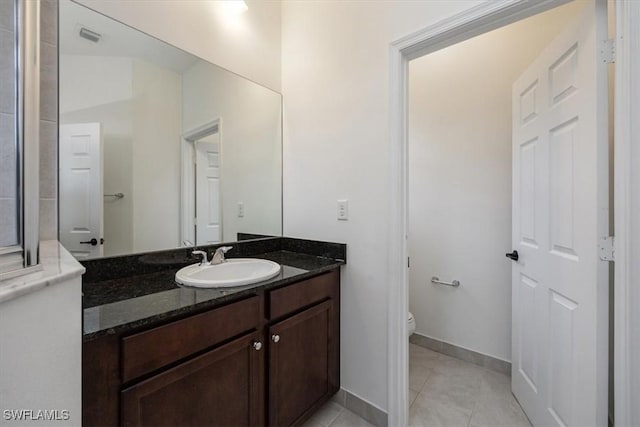 bathroom featuring tile patterned flooring, vanity, and toilet