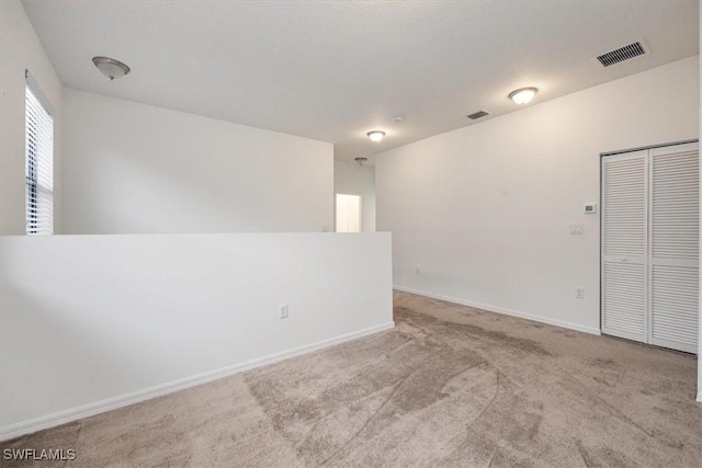 unfurnished room with light colored carpet