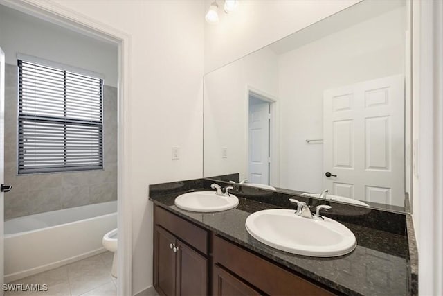 bathroom featuring tile patterned flooring, vanity, a bath, and toilet