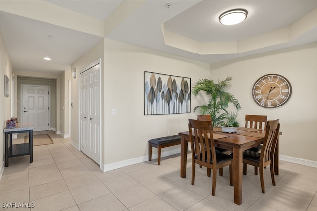 dining room featuring recessed lighting, a raised ceiling, baseboards, and light tile patterned floors