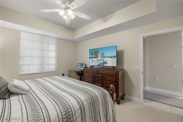 bedroom featuring a ceiling fan, light carpet, baseboards, and light tile patterned floors