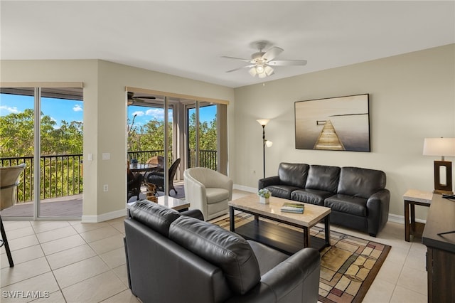 living room featuring light tile patterned floors, ceiling fan, and baseboards