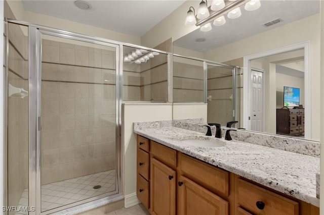 bathroom with a shower stall, visible vents, and vanity