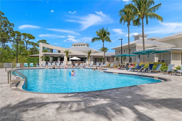 pool with a patio area and fence