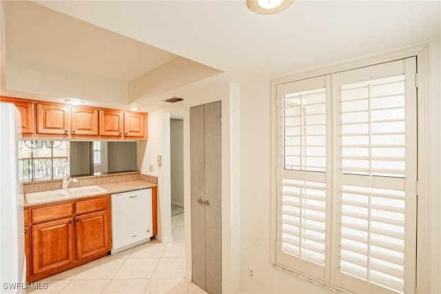 kitchen with sink, light tile patterned floors, and white appliances