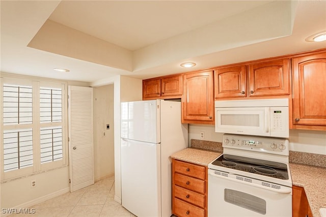 kitchen featuring light tile patterned floors and white appliances