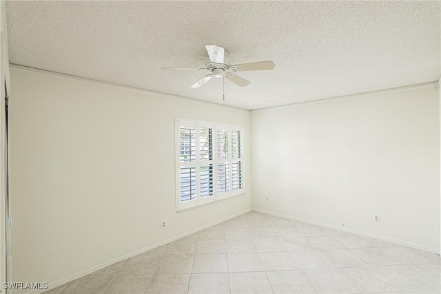 spare room featuring ceiling fan, light tile patterned flooring, and a textured ceiling