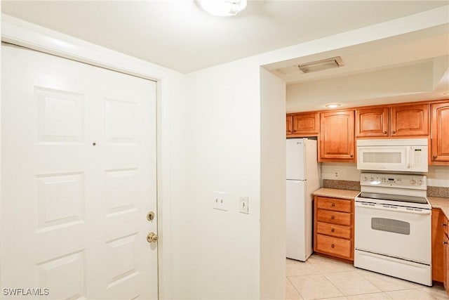 kitchen with light tile patterned floors and white appliances