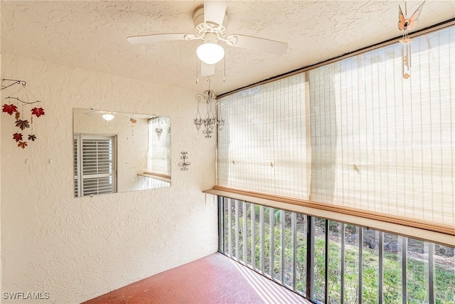 unfurnished sunroom with ceiling fan