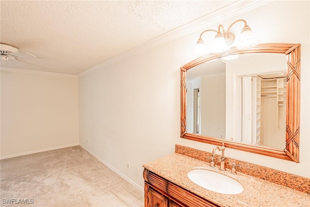 bathroom with ceiling fan, crown molding, a textured ceiling, and vanity