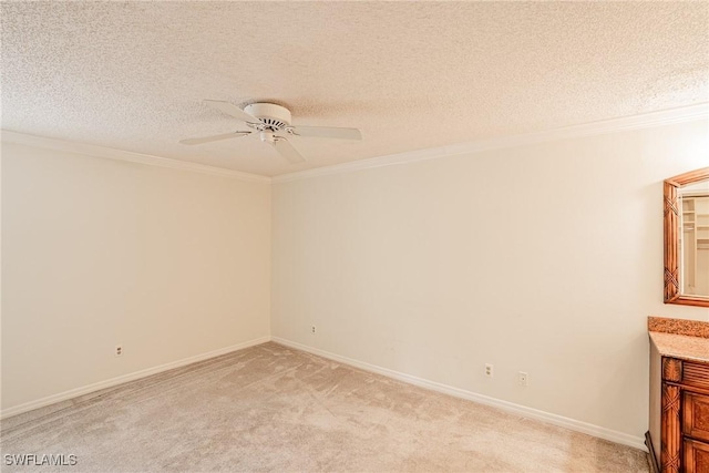 carpeted spare room with ceiling fan, crown molding, and a textured ceiling