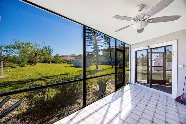 unfurnished sunroom featuring ceiling fan and plenty of natural light