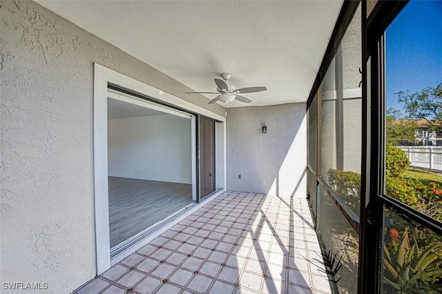 unfurnished sunroom featuring ceiling fan